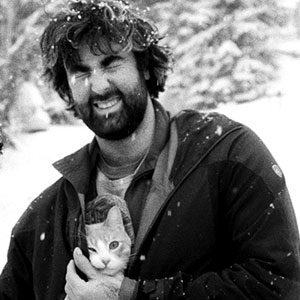 Jericho Leavitt is a white male with brown hair and beard. He is smiling with his eyes closed and holding a cat in his winter coat.
