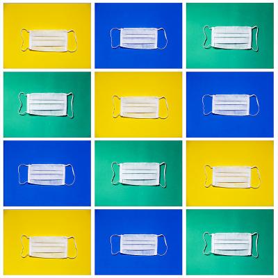 Picture of white surgical masks in a grid format. Masks are in different boxes with a yellow, blue, or green background. There are three columns and four rows of mask.  Picture also includes the Western Alumni logo in a Western blue ribbon.
