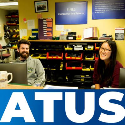 Two Western students seated at the ATUS equipment check-out desk