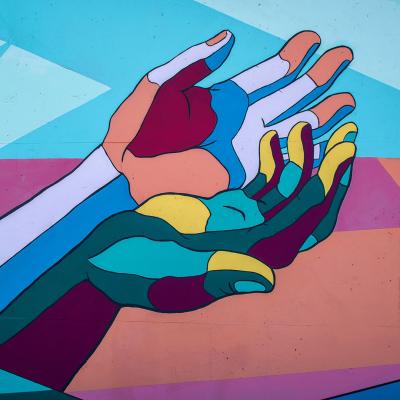 Colorful painting of arms outstretched with clasped hands