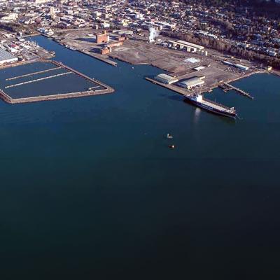 Aerial view of green waters of Bellingham Bay with the city in the background and the old Georgia Pacific plant in foreground.